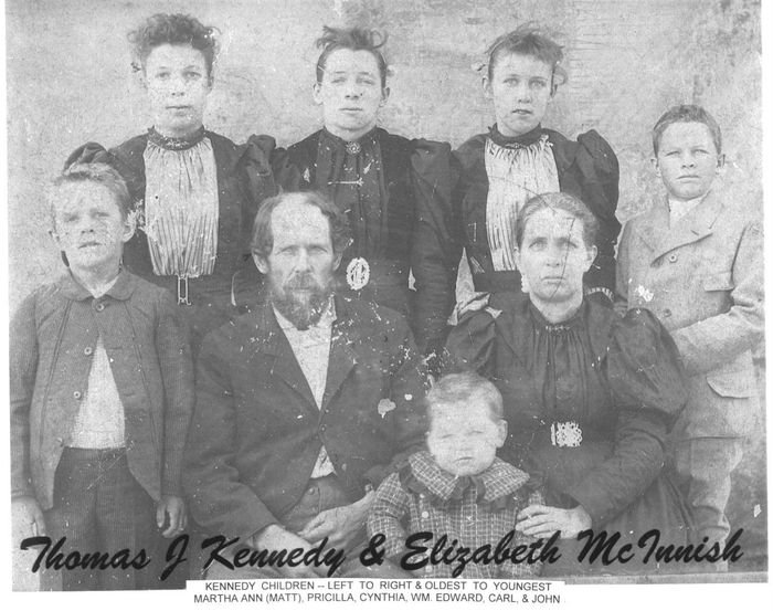 Thomas Jefferson Kennedy and family. This photo was probably taken somewhere around 1895.  The two adults, left to right, are Thomas Jefferson Kennedy and Sarah McInnish Kennedy.  The three young ladies in back, left to right are Matt, Priscilla, and Cynthia.  The three boys, left to right, are Edward, Carl and John.  Thomas had previously spelled his last name Canady.  Carl went on to become the principal of Red Hill School.  A later copy of this photo has Priscilla mysteriously painted out of the picture. Also missing is one of the sons, Nevin Kennedy, who was probably already out on his on at the time this photo was taken.  Nevin became a pillar of the community, back in the days when it was called Channahatchee.  He was a member of the board of trustees for the Red Hill School, helping to insure that the children in our area had a good facility, with good teachers, for acquiring an education